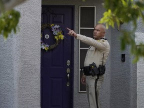 A police officer stands at the front door of the house of Clark County Public Administrator Robert Telles, Wednesday, Sept. 7, 2022, in Las Vegas.