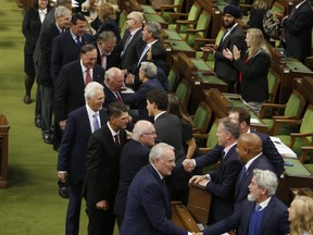 Prime Minister Justin Trudeau speaks with Paul Henderson and members of Team Canada from the 1972 Summit Series as they are honoured in the House of Commons, in Ottawa, Thursday, Sept. 22, 2022. THE CANADIAN PRESS/ Patrick Doyle