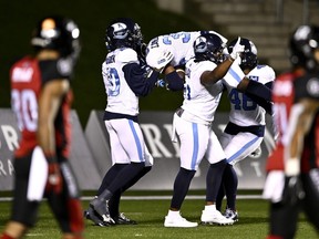 Argonauts players carry defensive back Maurice Carnell IV as they celebrate his picks-six in the fourth quarter last night in Ottawa. The Argos had five interceptions, two for TDs.