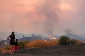 Eine Mutter steht mit ihrem fünfjährigen Sohn, dessen Schule während des Route Fire in der Nähe von Castaic, Kalifornien, am Mittwoch, den 31. August 2022, evakuiert wurde.