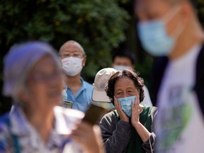 People line up to get tested for COVID-19 at a nucleic acid testing site in a residential area of Shanghai, China, Sunday, Sept. 25, 2022.