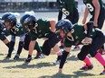 Four young football players in green jerseys from Eagles’ starting line.