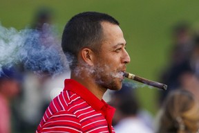 Team USA golfer Xander Schauffele smokes a cigar during the singles match play of the Presidents Cup golf tournament at Quail Hollow Club Setp. 25, 2022. Peter Casey-USA TODAY Sports