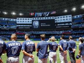 Tampa Bay Rays players and staff stand for a moment of silence on the death of Julia Budzinski, the eldest daughter of first base coach Mark Budzinski, ahead of a game against the Tampa Bay Rays at Rogers Centre on July 3, 2022 in Toronto, Canada.