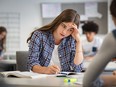 Anxious girl in class looking upset.