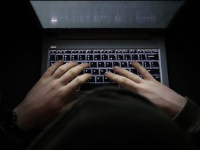 Hands type on a computer keyboard.