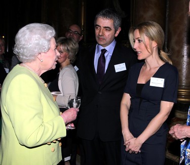 Queen Elizabeth II meets actors Rowan Atkinson (C) and Gillian Anderson (R) at a reception to celebrate the 200th anniversary of the year Charles Dickens was born, at Buckingham Palace, London on February 14, 2012.   (SEAN DEMPSEY/AFP via Getty Images)