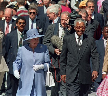 Queen Elizabeth II (L) and President Nelson Mandela walk from office of the president to parliament in Cape Town 20 March 1995. The Queen is on a week long celebratory visit to South Africa. (WALTER DHLADHLA/AFP via Getty Images)