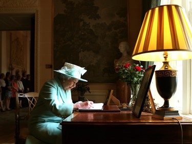 BELFAST, NORTHERN IRELAND - JUNE 25:  Queen Elizabeth II signs the visitor book prior to departing Hillsborough Castle, on the third and final day of the Queen's visit to Northern Ireland, on June 25, in Belfast, Northern Ireland. (Photo by Brian Lawless - WPA Pool/Getty Images)