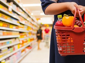 woman holding shopping basket in supermarket