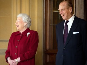Queen Elizabeth II and Prince Philip, Duke of Edinburgh react as they bid farewell to Irish President Michael D. Higgins and his wife Sabina (not pictured) at the end of their official visit at Windsor Castle on April 11, 2014 in Windsor, United Kingdom.
