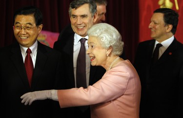 Britain's Queen Elizabeth II (2nd R) gestures as Britain's Prime Minister Gordon Brown (2nd L), China's President Hu Jintao (L) and President of the European Commission Jose Manuel Barroso (R) look on during a reception for world leaders attending the G20 summit at Buckingham Palace, in London, on April 1, 2009. (KIRSTY WIGGLESWORTH/POOL/AFP via Getty Images)