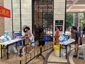 Medical workers in protective suits collect swabs from residents at a residential compound in Nanshan district, following a COVID-19 outbreak in Shenzhen, Guangdong province, Sept. 3, 2022.