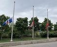 Flowers laid under lowered flags in front of Toronto Police Traffic Services on Tuesday, September 13, 2022 following the murder of Const.  Andrew Hong.