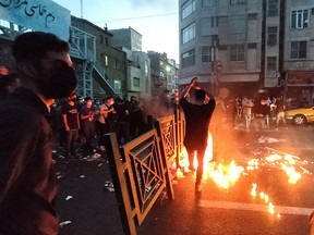 People light a fire during a protest over the death of Mahsa Amini, a woman who died after being arrested by the Islamic republic's "morality police," in Tehran, Iran September 21, 2022.