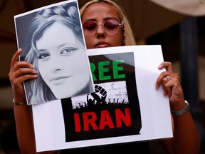 Eine Frau hält Plakate zur Unterstützung der Anti-Regime-Proteste im Iran nach dem Tod von Mahsa Amini während einer Protestaktion in Valletta, Malta, am 27. September 2022.