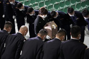 Members of the honour guards bow to Akie Abe, wife of former Prime Minister Shinzo Abe, as she leaves with the cinerary urn containing his ashes at the end of the state funeral at Nippon Budokan in Tokyo, Japan, Sept. 27, 2022.