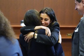 Attorney Joel Rich hugs attorney Camille Vasquez as attorney Ben Chew, right, looks on, at the end of the day's proceedings at the Fairfax County Circuit Courthouse, Monday, May 16, 2022, in Fairfax.