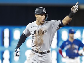 The New York Yankees’ Aaron Judge celebrates after hitting his 61st home run of the season in the seventh inning against the Blue Jays to tie Roger Maris’ American League record last night at the Rogers Centre.