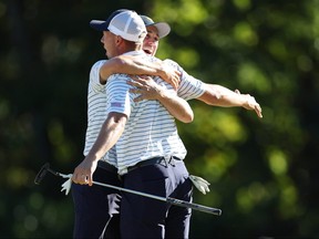 Justin Thomas (R) of the United States Team and Jordan Spieth (L) of the United States Team celebrate winning 2&1 over Adam Scott of Australia and Cam Davis of Australia and the International Team during Friday four-ball matches on day two of the 2022 Presidents Cup at Quail Hollow Country Club in Charlotte, North Carolina. (Photo by