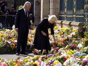 Der britische König Karl III. (links) und die britische Königin Camilla, Königingemahlin (rechts), sehen sich am Dienstag, den 13. September 2022, während seines Besuchs in Nordirland vor dem Hillsborough Castle in Belfast florale Ehrungen an.