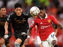Manchester United's Brazilian midfielder Fred (right) vies with Arsenal's Japanese defender Takehiro Tomiyasu (left) during English Premier League action at Old Trafford in Manchester, England, Sept. 4, 2022.