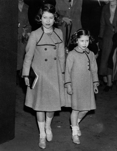 Picture taken on March 12, 1937 showing Princesses Elizabeth (L)and Margaret leaving the Royal Agricultural Hall after watching the competitions at the Pony Show. (CENTRAL PRESS PHOTO LTD/AFP via Getty Images)