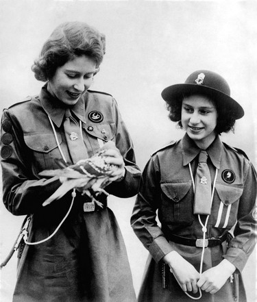 Picture taken on 1943 showing Princess Elizabeth, the futur Queen Elizabeth II, with her sister Princess Margaret admiring a pigeon before its departure with their message. (AFP via Getty Images)
