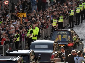 The hearse carrying the coffin of Queen Elizabeth II leaves St. Giles' Cathedral in Edinburgh, Scotland, Tuesday, Sept. 13, 2022, headed for Edinburgh airport.