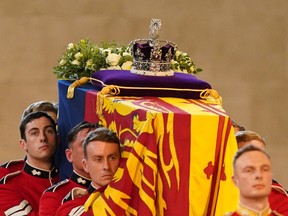TOPSHOT - Pallbearers from The Queen's Company, 1st Battalion Grenadier Guards carry the coffin of Queen Elizabeth II into Westminster Hall at the Palace of Westminster in London on September 14, 2022, to Lie in State following a procession from Buckingham Palace. - Queen Elizabeth II will lie in state in Westminster Hall inside the Palace of Westminster, from Wednesday until a few hours before her funeral on Monday, with huge queues expected to file past her coffin to pay their respects. (Photo by Jacob King / POOL / AFP) (Photo by JACOB KING/POOL/AFP via Getty Images)