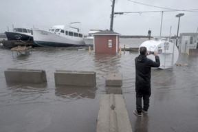 A resident takes photographs of flooding following the passing of Hurricane Fiona, later downgraded to a post-tropical cyclone, in Shediac, N.B., Sept. 24, 2022.