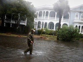 A local resident walks in a flooded street as Hurricane Ian bears down on Charleston, SC, Sept.  30, 2022.