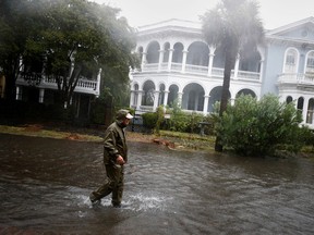 A local resident walks in a flooded street as Hurricane Ian bears down on Charleston, SC, Sept. 30, 2022.
