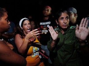 A local communist party officer speaks to protesters in front of a communist party office in a protest against the electricity shortage during a blackout in the aftermath of Hurricane Ian in Havana, Cuba, Sept. 29, 2022.