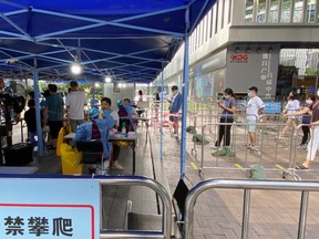 Medical workers in protective suits collect swabs at a testing site at the Software Park in Nanshan district, following the COVID-19 outbreak in Shenzhen, Guangdong province, China, Friday, Sept. 2, 2022.