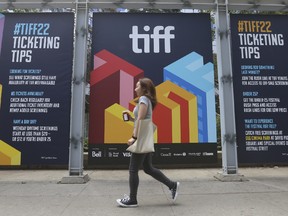 A person walks past signage on King St. W. and John St. which is the epicentre for the Toronto International Film Festival that runs Sept. 8-18 . Jack Boland/Toronto Sun