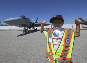 Marky “M-Dog” Czutrin, aged 8, is an avid plane enthusiast and also a three time SickKids cancer patient diagnosed with Acute Lymphoblastic Leukemia at age three. Marky got to join in in the Canadian International Air Show sneak peek at Pearson International airport showing off his “guns in front of the RCAF’s CF-18 Hornet Demonstration fighter jet on Thursday September 1, 2022. Jack Boland/Toronto Sun/Postmedia Network