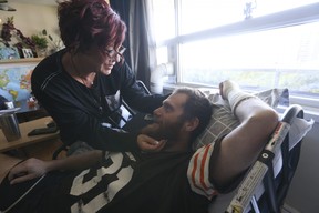 Justin Smith, 39, who has been bedridden since he was intentionally run down by a driver and left for dead last month, is recovering in his Etobicoke apartment with his wife Magda Szozda by his side on Friday, Sept. 23, 2022.