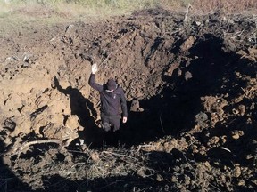Ein Polizist steht auf dem Boden eines Kraters, der durch einen russischen Militärschlag auf einem Gelände des Kernkraftwerks Pivdennoukrainsk in der Region Mykolajiw, Ukraine, hinterlassen wurde, auf diesem Handout-Bild, das am 19. September 2022 veröffentlicht wurde.