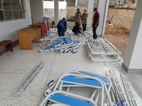 Ugandan medical staff members assemble beds to be used in the Ebola treatment isolation unit at Mubende Regional Referral Hospital in Uganda, Saturday, Sept. 24, 2022.