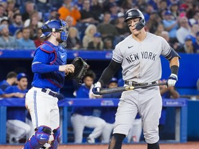 Aaron Judge #99 of the New York Yankees reacts to striking out beside Danny Jansen #9 of the Toronto Blue Jays in the eighth inning during their game on Monday night.