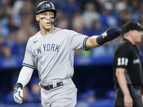 Yankees’ Aaron Judge celebrates as he scores off a Gleyber Torres single in the sixth inning at Rogers Centre last night. Judge walked four times in the game.