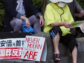 Tense Japan holds funeral for slain ex-leader Abe 2 A protester rests before joining a demonstration to oppose the state funeral of former Japanese Prime Minister Shinzo Abe in Tokyo on September 27, 2022.