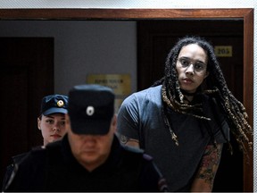 In this file photo taken on August 04, 2022 US Women National Basketball Association's (WNBA) basketball player Brittney Griner, who was detained at Moscow's Sheremetyevo airport and later charged with illegal possession of cannabis, is escorted to the courtroom to hear the court's final decision in Khimki outside Moscow.