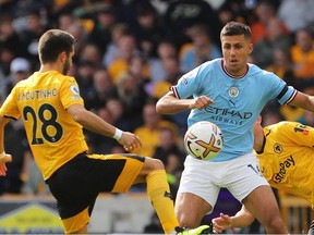 Wolverhampton Wanderers' Portuguese midfielder Joao Moutinho (L) competes with Manchester City's Spanish midfielder Rodri during the English Premier League football match between Wolverhampton Wanderers and Manchester City at the Molineux stadium in Wolverhampton, central England on September 17, 2022.