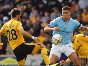Wolverhampton Wanderers' Portuguese midfielder Joao Moutinho (L) competes with Manchester City's Spanish midfielder Rodri during the English Premier League football match between Wolverhampton Wanderers and Manchester City at the Molineux stadium in Wolverhampton, central England on September 17, 2022.