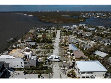 An aerial picture taken on Sept. 29, 2022 shows a big washed up boat sitting in the middle of a street in the aftermath of Hurricane Ian in Fort Myers, Fla.