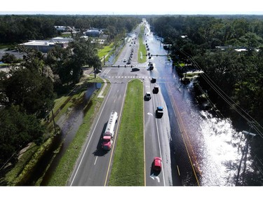 An aerial photo, shows vehicles moving through receding flood waters as they return to New Smyrna Beach, Fla. on Sept. 30, 2022, after Hurricane Ian slammed the area.