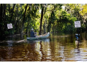 A man paddles a canoe through a flooded neighbourhood in New Smyrna Beach, Fla. on Sept. 30, 2022, after Hurricane Ian slammed the area.