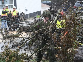 Cpl. Owen Donovan of the Cape Breton Highlanders removes brush under the direction of Nova Scotia Power officials along Steeles Hill Road in Glace Bay, N.S., Sept. 26, 2022.